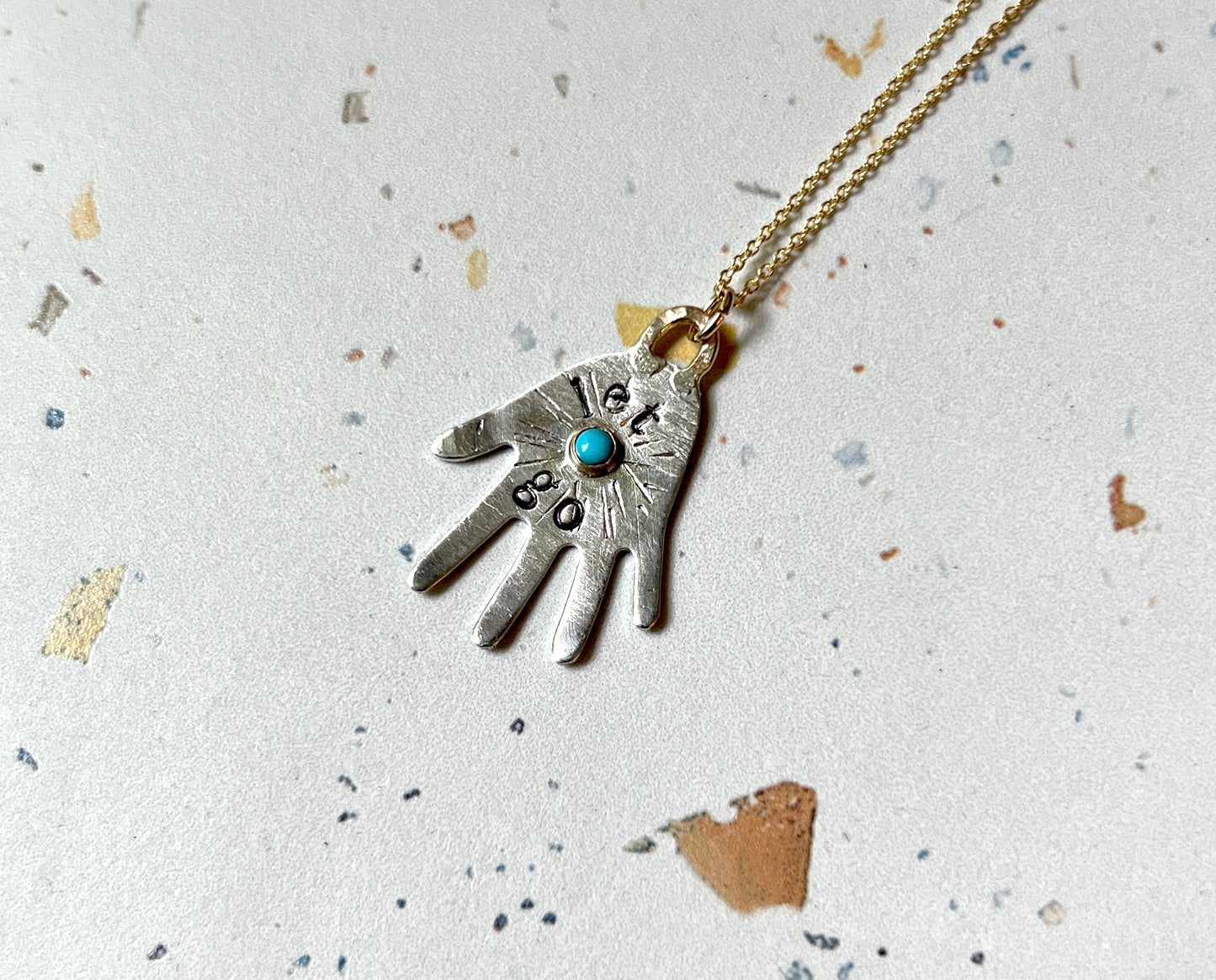 Let Go sterling silver hand pendant with turquoise pendant